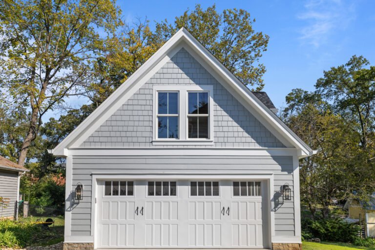 Grey James Hardie siding with shingle accents and white trim on a renovated garage exterior